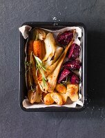 Oven-roasted root vegetables in a roasting tin (seen from above)