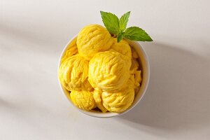 A bowl of lemon ice cream garnished with mint leaves