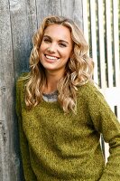 A young blonde woman wearing a green knitted jumper