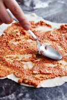 Lahmacun (Turkish pizza) being made: yeast dough being spread with a minced meat ragout