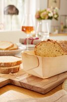 Home-made bread in a poplar wood baking mould on a chopping board