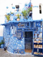 Weiß-blauer Künstlerladen verziert mit Handabdrücken in der Medina von Asilah, Marokko