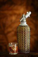 Soda-Siphonflasche und ein Glas Whisky mit Eiswürfeln