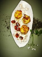 Potato cakes on mushroom carpaccio with fried tomatoes