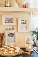 A Christmassy kitchen scene with cinnamon stars and favourite recipes framed on the wall