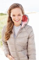 The young blonde woman outside wearing a beige quilted jacket
