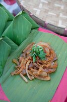 Spicy pork rind salad on a banana leaf (Thailand)