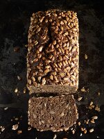 A loaf of sunflower seed bread, sliced, seen from above