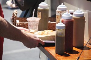 A burger and various salsas at a food truck festival in California, USA