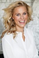 A laughing blonde woman wearing a white blouse