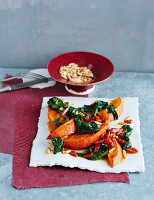 Pumpkin wedges on wilted spinach with goji berries