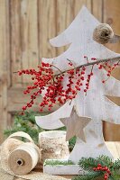 Tannenbaum aus Holz geschmückt mit Sternanhänger & Winterbeerenzweig (Ilex Verticillata)