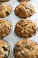 Blueberry and yoghurt muffins with oats in a muffin tin