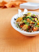 Fried beef with oranges, green beans, carrots and onions on a bed of rice
