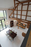 Modern dining room with exposed wooden beams and lamp above the table