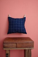 Hand-sewn cushion hung on wall from leather straps