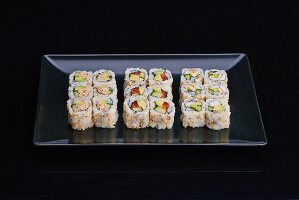 Various California maki on a black plate