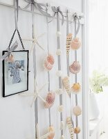 Seashells stuck on ribbons and hung from hooks