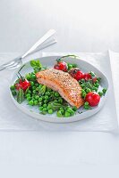 Fried salmon with tomatoes and peas
