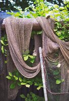 An old fishing net hanging over a fence