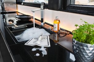 A modern granite work surface with a black ceramic sink