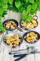Mediterranes Raclette vom Grill: Kartoffeln, Fenchel und Oliven mit Käse in kleinen Pfännchen