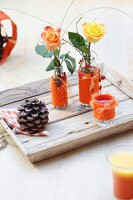 Roses in glass vases decorated with orange felt covers