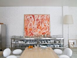 Edelstahlregal mit Geschirr, vor geweisselter Ziegelwand, modernes Bild