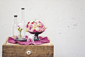 Domed arrangement of summer flowers, glass vessels & china figurine