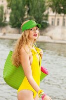 Junge Frau in gelbem Badeanzug geht am Fluss entlang