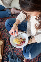 A person eating a picnic-style Christmas meal on a kilim rug