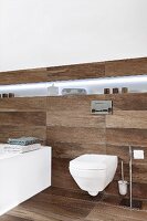 Modernes Hänge-WC und beleuchtete Ablagefläche in Designerbad, Fliesen in dunkler Dielenoptik