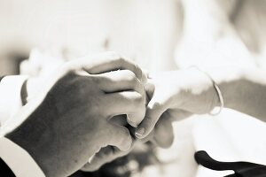 Man putting wedding ring on wife's finger