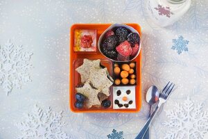 Verschiedene winterliche Snacks in Plastikbox zum Mitnehmen