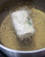 Shiitake mushroom rice paper packages being fried in oil