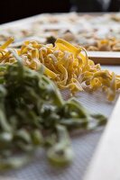 Fresh, handmade tagliatelle pasta drying on a rack