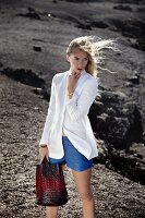 A blonde woman wearing a white blazer and blue shorts