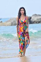 A woman on a beach wearing a brightly coloured dress