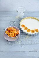 Apricots being placed on a cheese tart topping