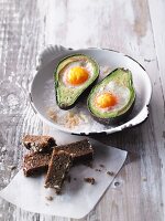Eggs in an avocado baked in the oven served with wholemeal bread