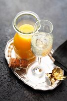 A glass of sparkling wine with orange juice