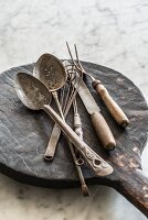 Various old cooking utensils on a wooden board