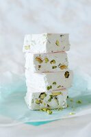 A stack of white nougat with pistachio nuts