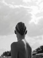 Young woman with elaborately braided hair in water (monochrome photo)