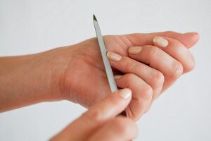 A woman filing her fingernails (close-up)