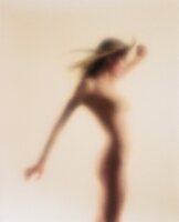 Young, nude woman with wind-blown hair; blurred