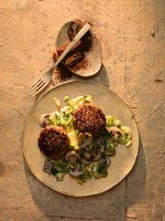 Oriental wild boar burgers with a potato and herb sauce served with salad