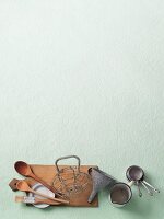 Various kitchen utensils on a pastel green surface