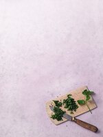 Chopped herbs on a chopping board with knife