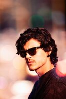 Junger Mann in Tweedsakko mit Sonnenbrille